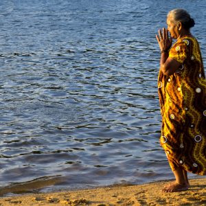 un'anziana signora prega in riva al mare a sri lanka